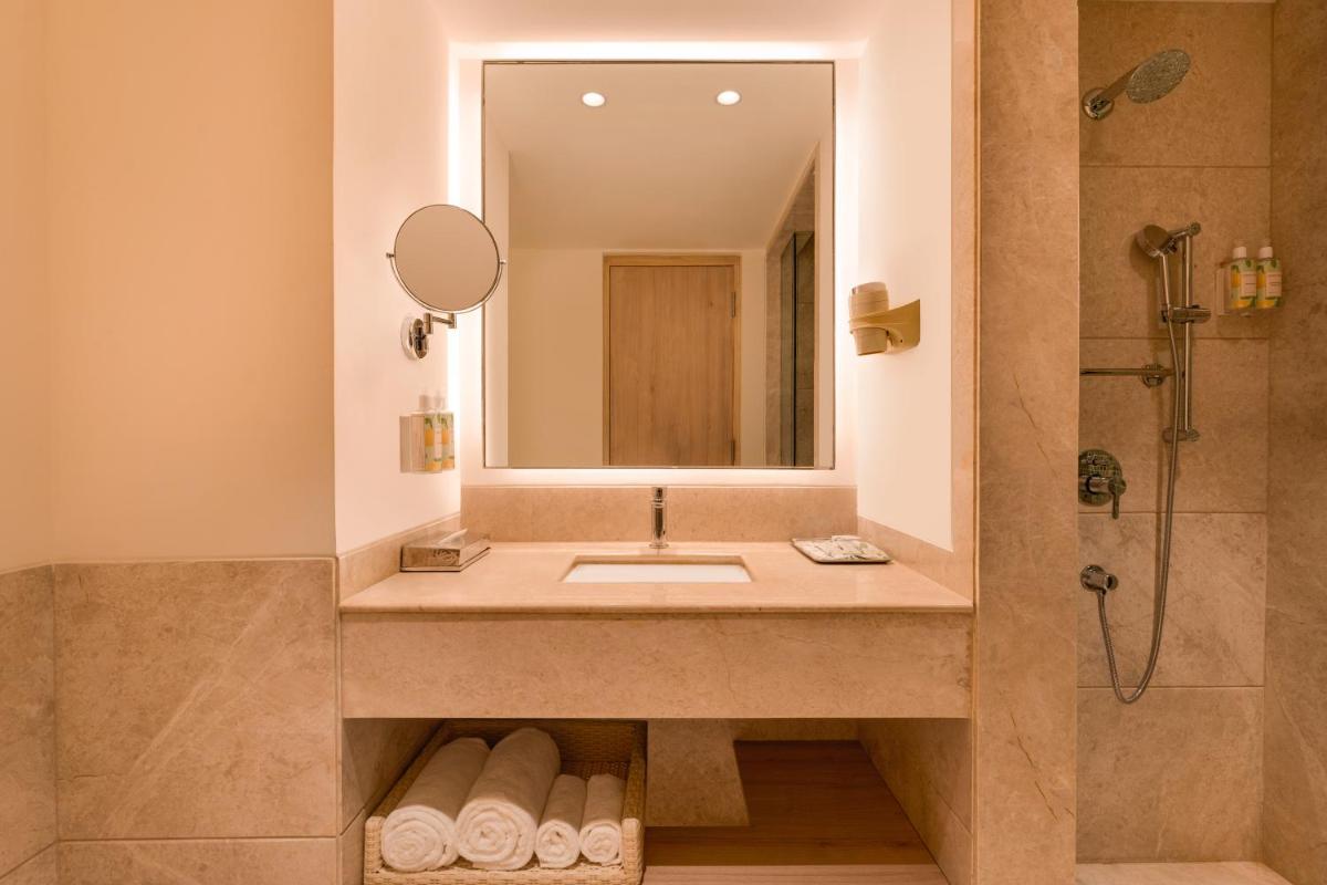 a bathroom with a sink and a shower at Lemon Tree Premier Hitec City Hyderabad in Hyderabad