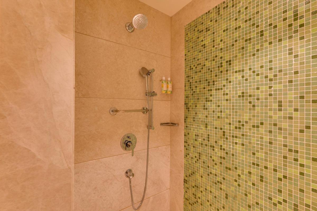 a bathroom with a shower with a glass door at Lemon Tree Premier Hitec City Hyderabad in Hyderabad
