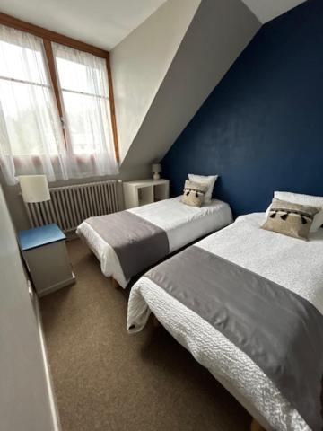 une chambre avec deux lits et un mur bleu dans l'établissement Hôtel Spa & Restaurant Ô Pervenches, à Chambéry