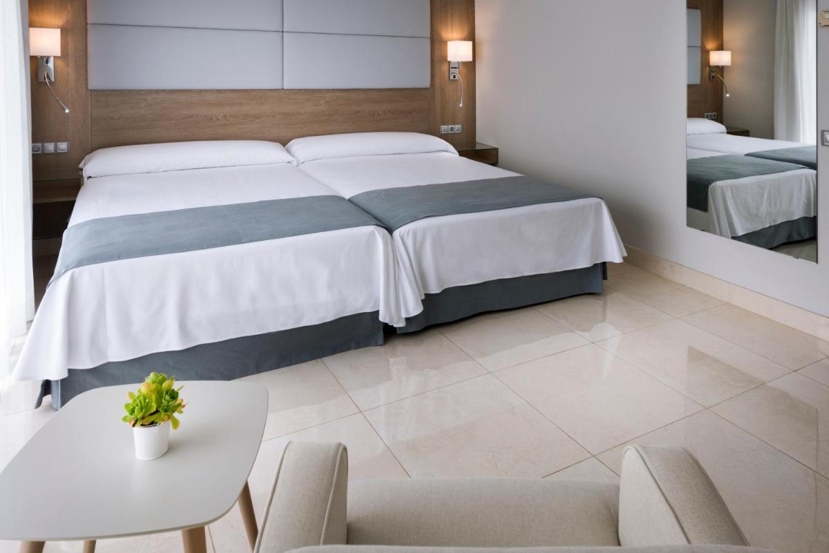 Un dormitorio con una cama y una mesa y sillas. en Mediterraneo Bay Hotel & Resort, en Roquetas de Mar