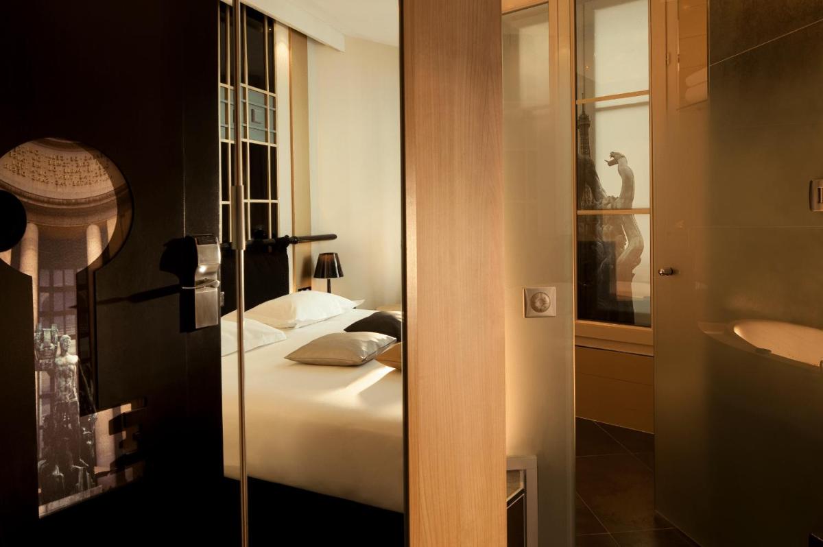 une chambre avec un lit et une salle de bains avec un miroir dans l'établissement Secret de Paris - Hotel & Spa, à Paris