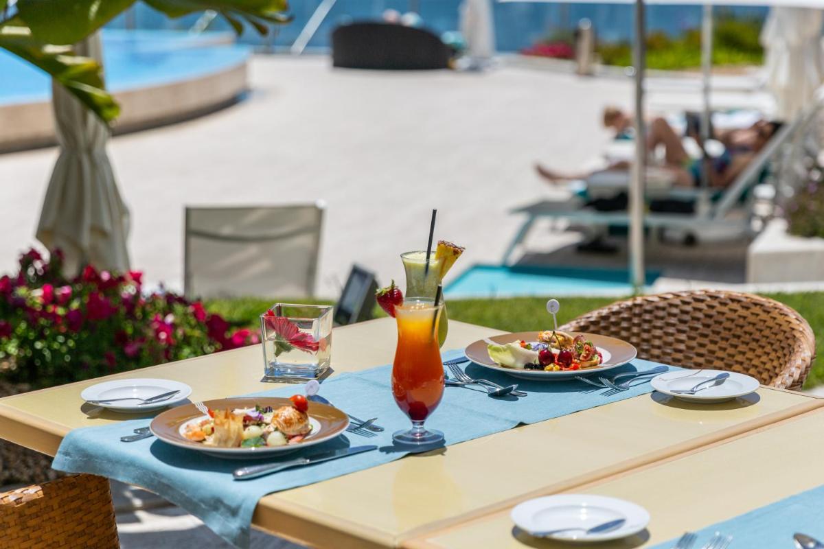 uma mesa com dois pratos de comida e uma bebida em Hotel Cascais Miragem Health & Spa em Cascais