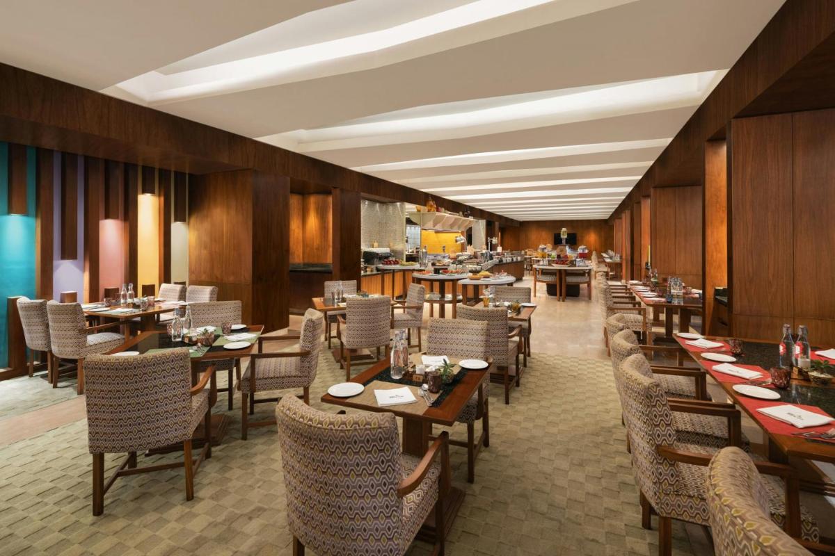 a dining room with tables and chairs and a restaurant at ITC Sonar, a Luxury Collection Hotel, Kolkata in Kolkata