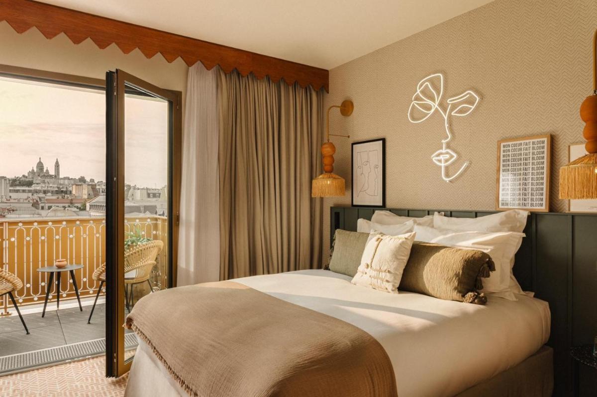 une chambre avec un grand lit et un balcon dans l'établissement Bloom House Hôtel & SPA, à Paris 106 autres photos