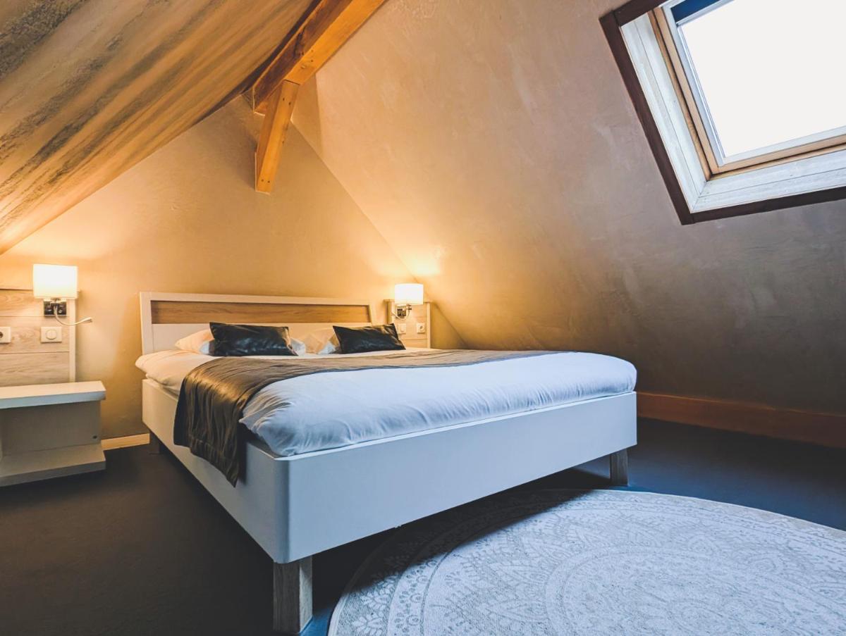 Un ou plusieurs lits dans un hébergement de l'établissement Hôtel Le Dormeur