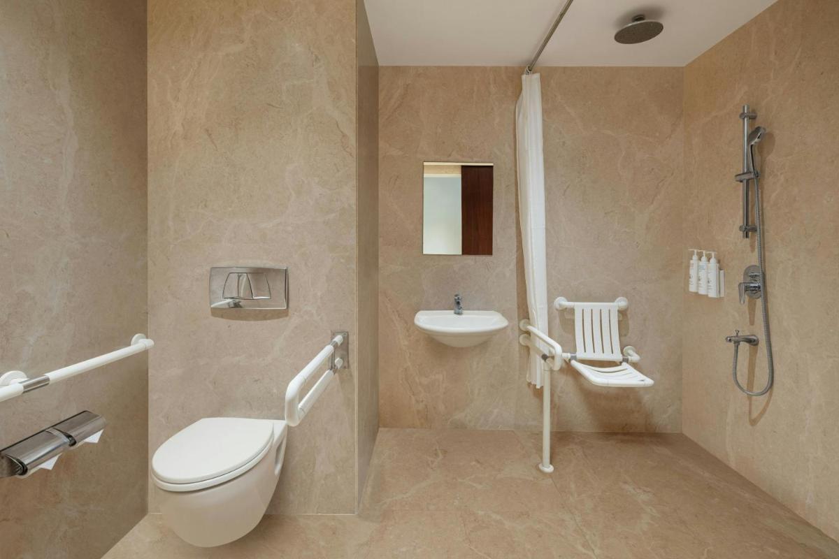 a bathroom with a toilet and a sink and a shower at Renaissance Ahmedabad Hotel in Ahmedabad