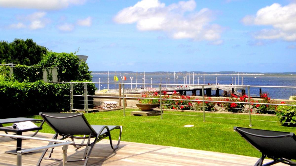 une terrasse avec des chaises et une vue sur l'eau dans l'établissement Hôtel Point France, à Arcachon