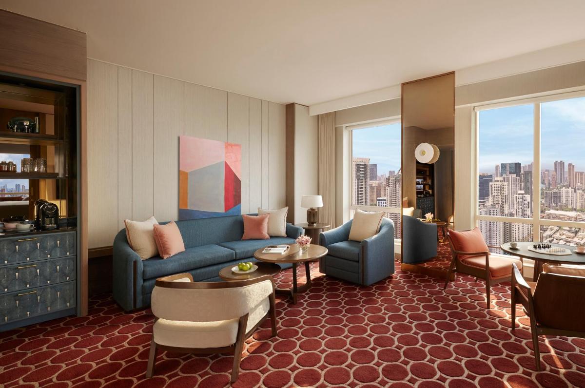 a living room with a blue couch and a table at Four Seasons Hotel Mumbai in Mumbai