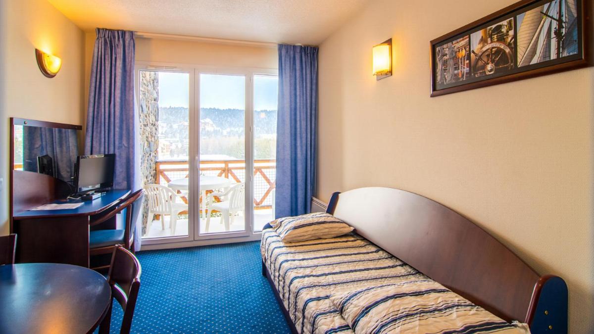 Télévision ou salle de divertissement dans l'établissement Vacancéole - Appart'Vacances Pyrénées 2000