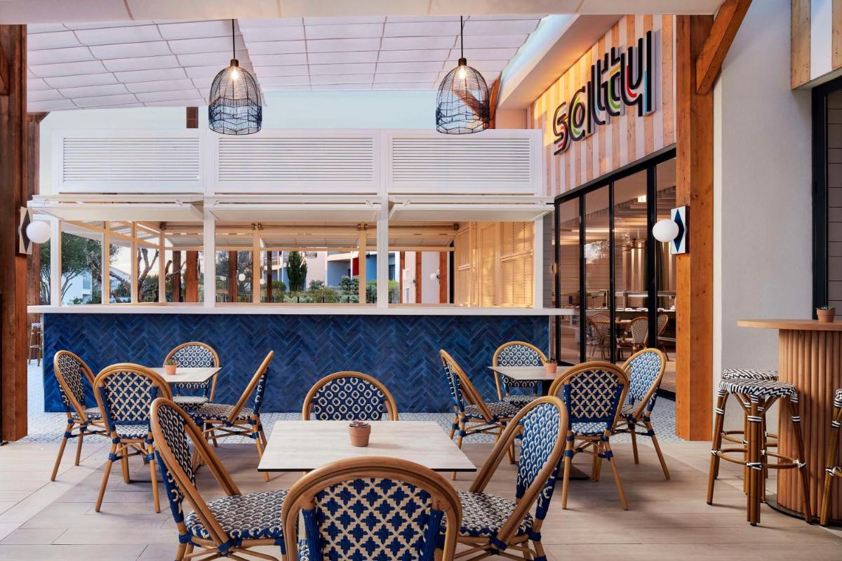 um restaurante com mesas e cadeiras em frente a uma loja em Tivoli Alvor Algarve - All Inclusive Resort em Alvor um restaurante com mesas e cadeiras em frente a uma loja em Tivoli Alvor Algarve - All Inclusive Resort em Alvor
