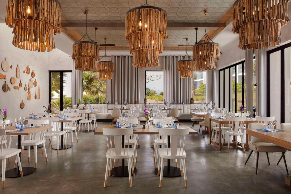 uma sala de jantar com mesas, cadeiras e lustres em Tivoli Alvor Algarve - All Inclusive Resort em Alvor mais 67 fotografias