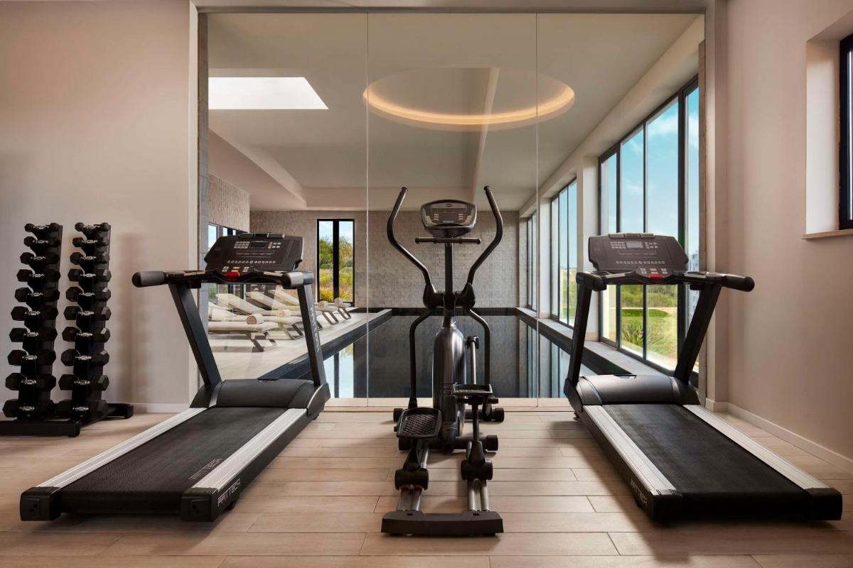 uma sala de ginástica com duas esteiras e uma academia em Tivoli Alvor Algarve - All Inclusive Resort em Alvor