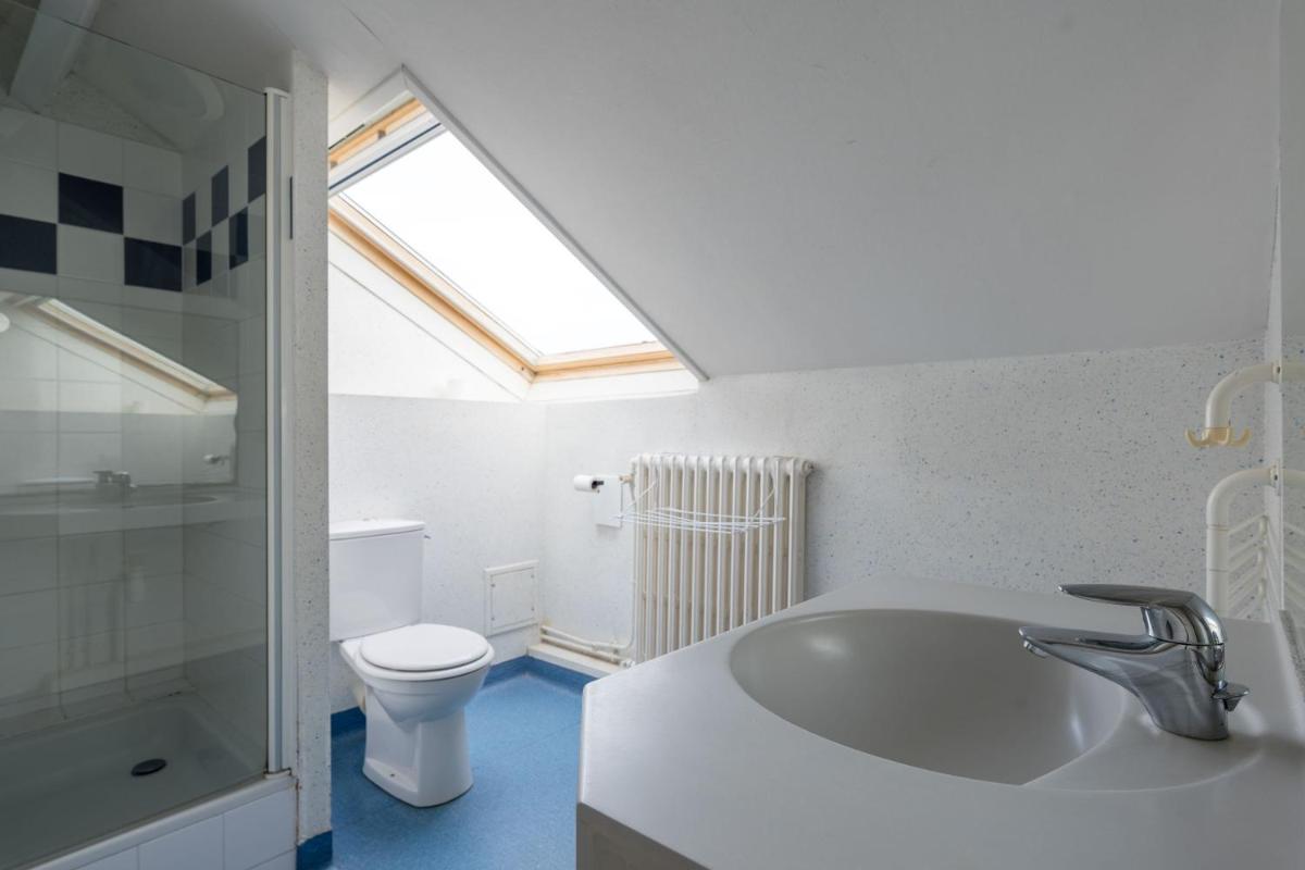 La salle de bains est pourvue d'un lavabo, de toilettes et d'une lucarne. dans l'établissement TERNELIA Le Vent Du Large, à Saint-Gilles-Croix-de-Vie