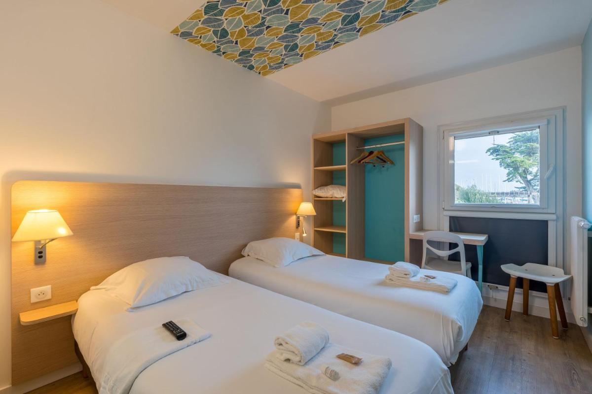 une chambre d'hôtel avec deux lits et une fenêtre dans l'établissement TERNELIA Le Vent Du Large, à Saint-Gilles-Croix-de-Vie