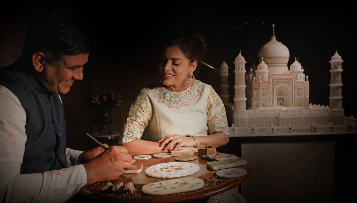 a man and a woman standing in front of a cake at Taj Agra in Agra