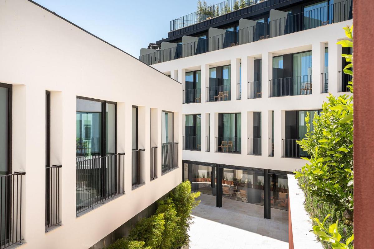 um prédio de apartamentos com grandes janelas e plantas em 3HB Faro em Faro