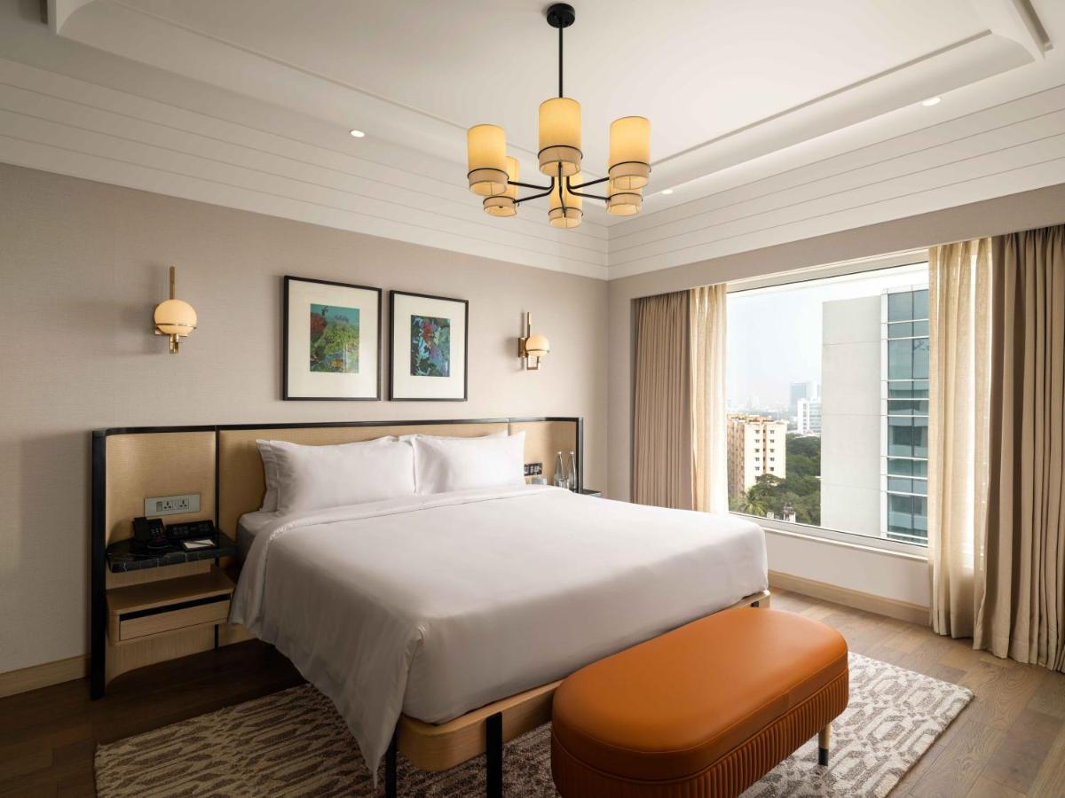 a bedroom with a large bed and a large window at Pullman Chennai Anna Salai - Premium Brand By Accor in Chennai