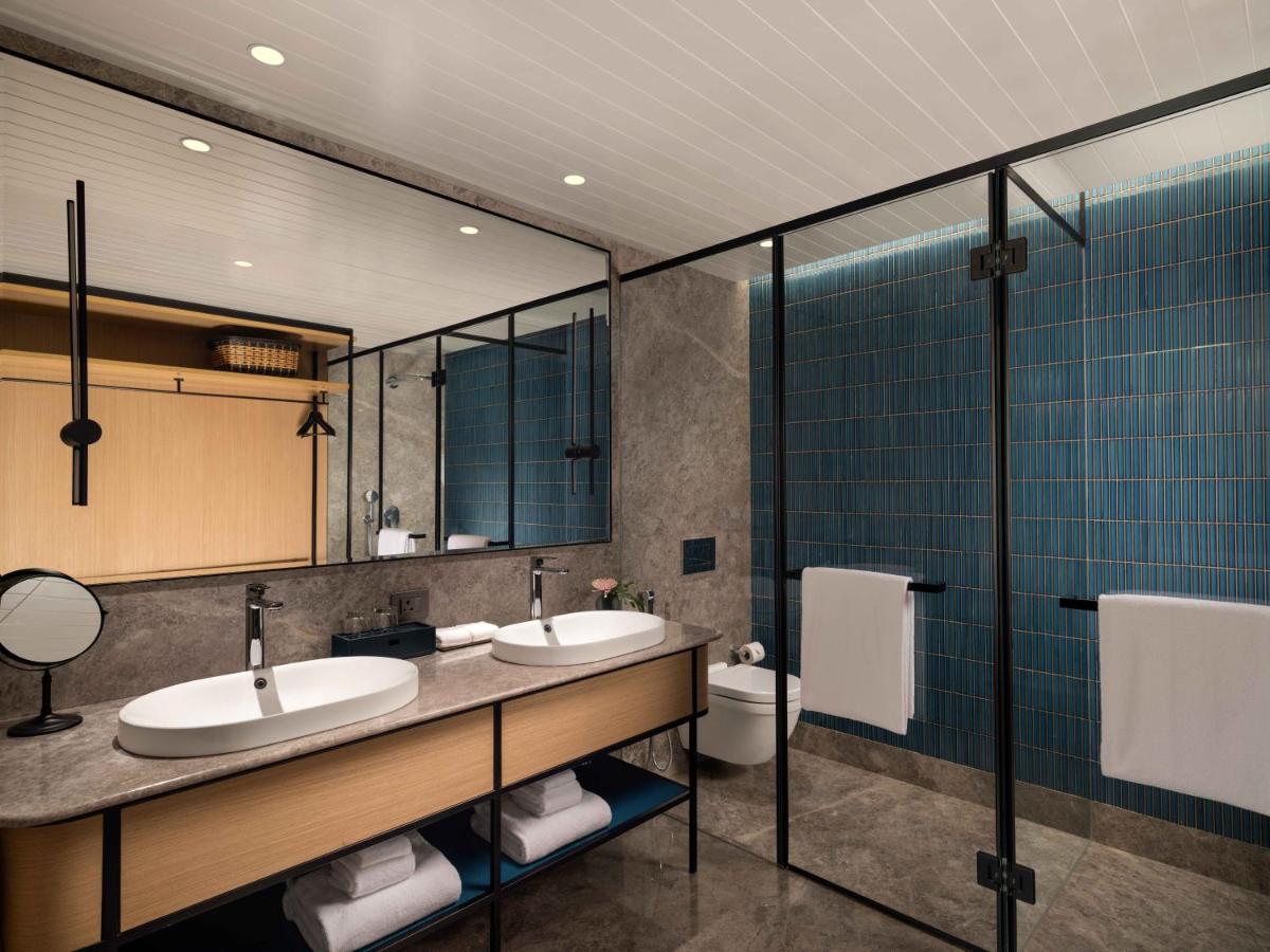 a bathroom with two sinks and a toilet at Pullman Chennai Anna Salai - Premium Brand By Accor in Chennai