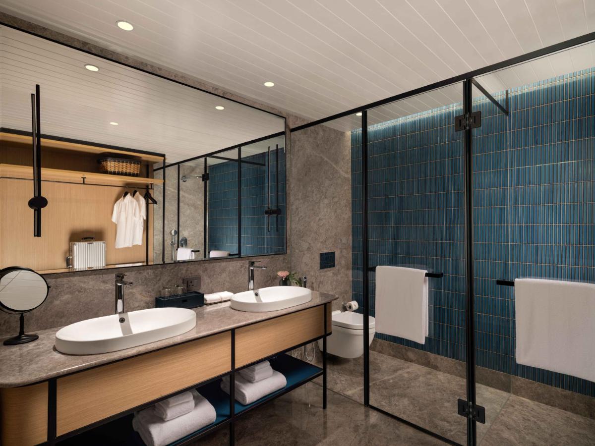 a bathroom with two sinks and a toilet at Pullman Chennai Anna Salai - Premium Brand By Accor in Chennai