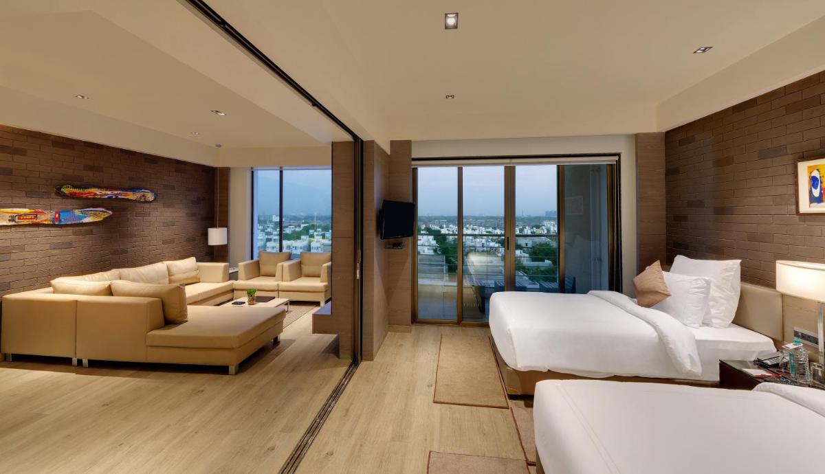 a bedroom with a bed and a living room at Wyndham Ahmedabad Shela in Ahmedabad
