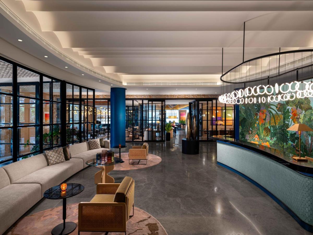a lobby with couches and chairs in a building at Pullman Chennai Anna Salai - Premium Brand By Accor in Chennai