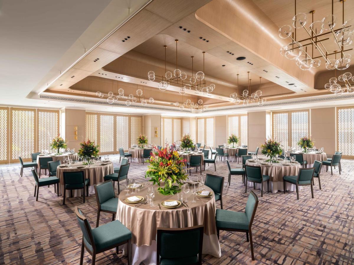 a banquet room with tables and chairs and chandeliers at Pullman Chennai Anna Salai - Premium Brand By Accor in Chennai