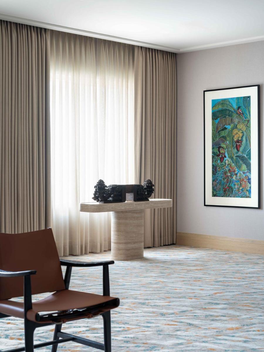 a room with a table and two chairs in front of a window at Pullman Chennai Anna Salai - Premium Brand By Accor in Chennai