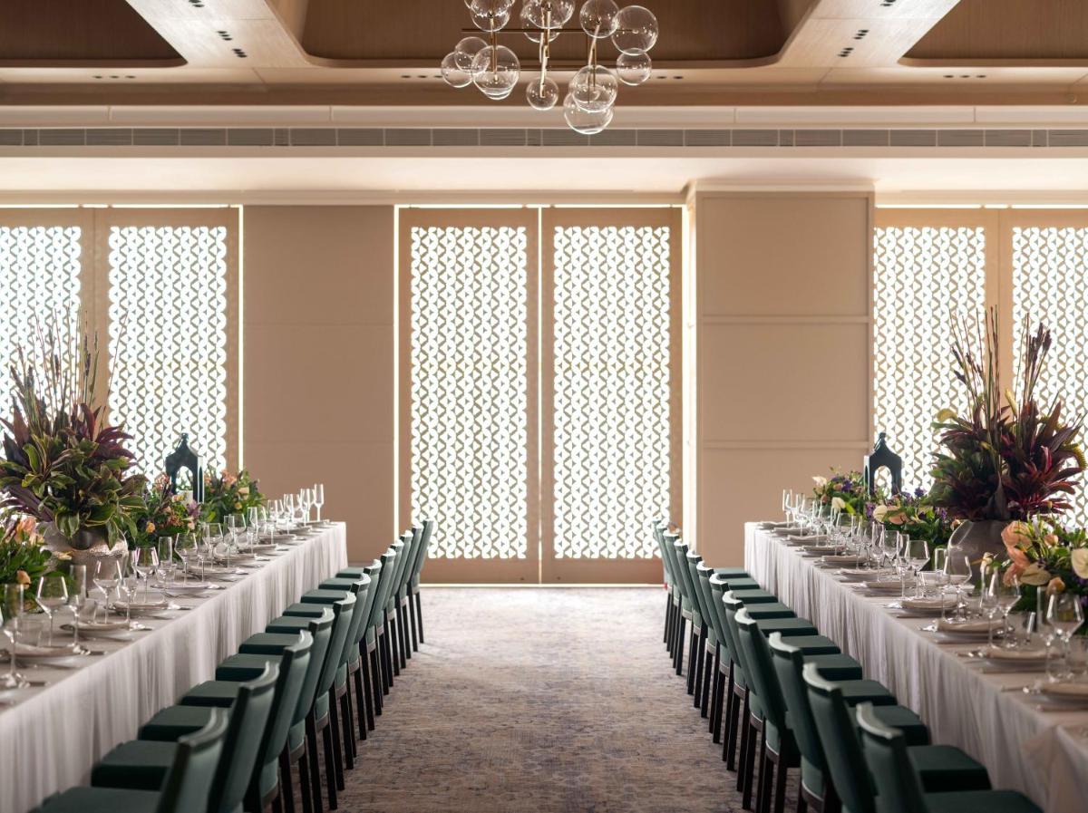 a row of tables in a room with green chairs at Pullman Chennai Anna Salai - Premium Brand By Accor in Chennai