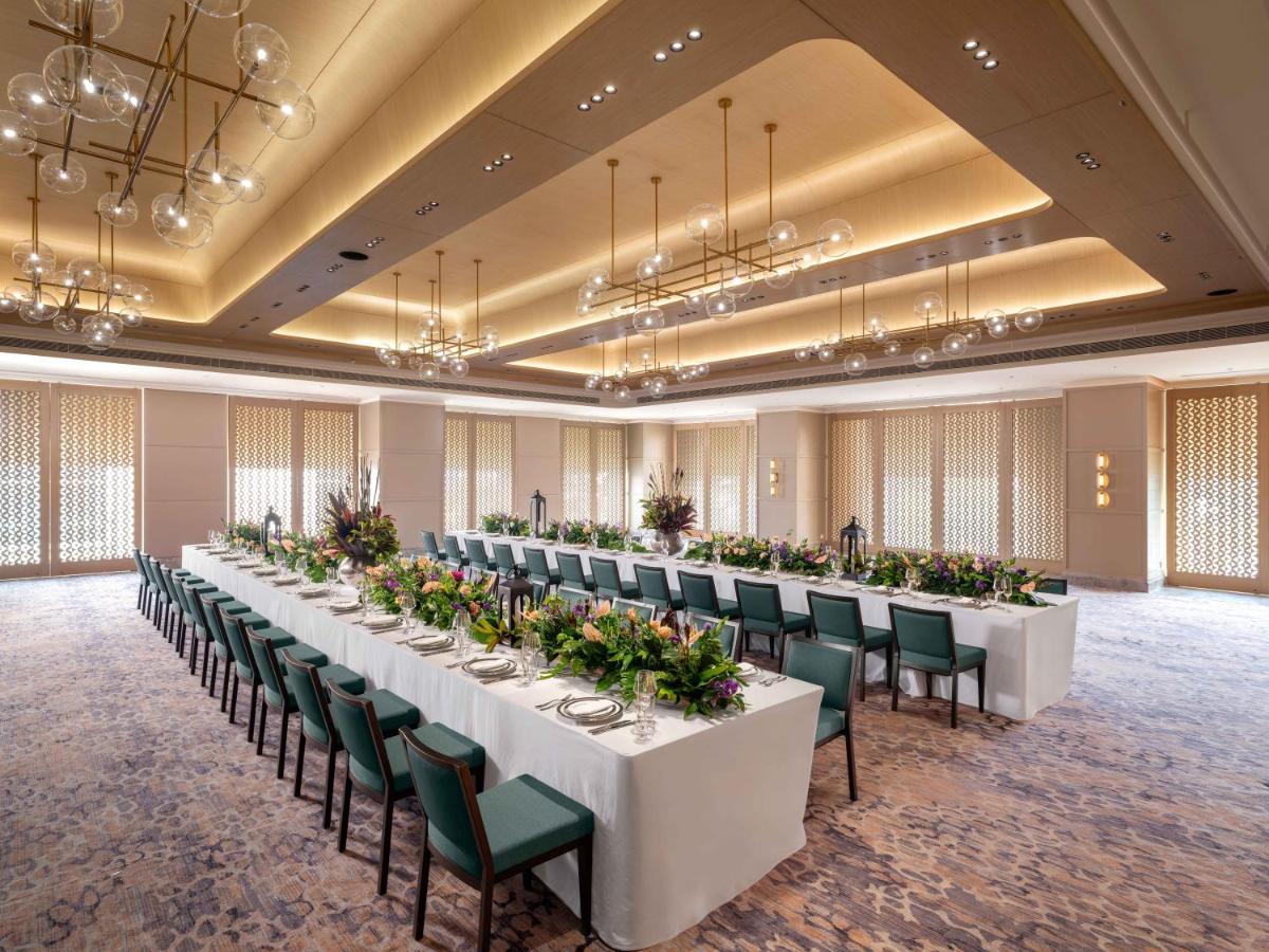 a large banquet hall with white tables and green chairs at Pullman Chennai Anna Salai - Premium Brand By Accor in Chennai