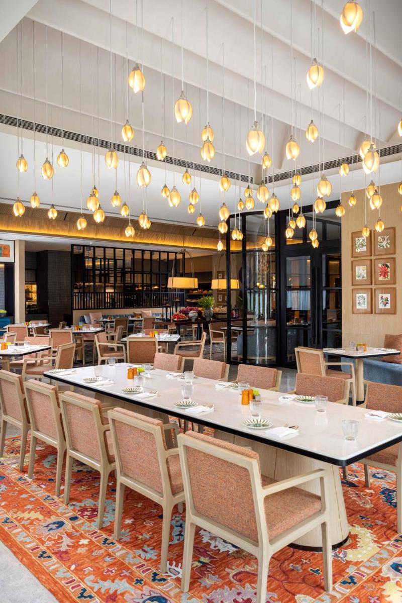 a large dining room with a large table and chairs at Pullman Chennai Anna Salai - Premium Brand By Accor in Chennai