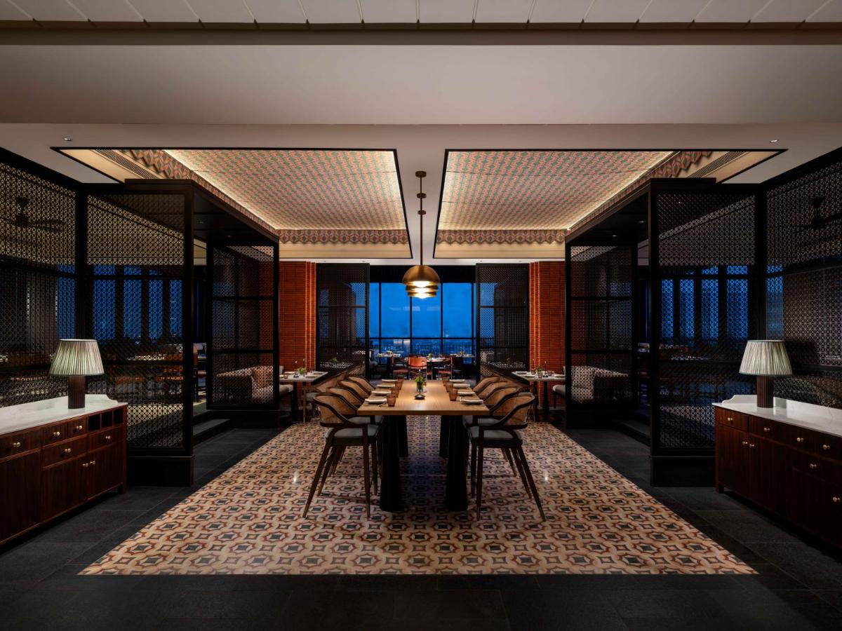 a dining room with a table and chairs at Pullman Chennai Anna Salai - Premium Brand By Accor in Chennai