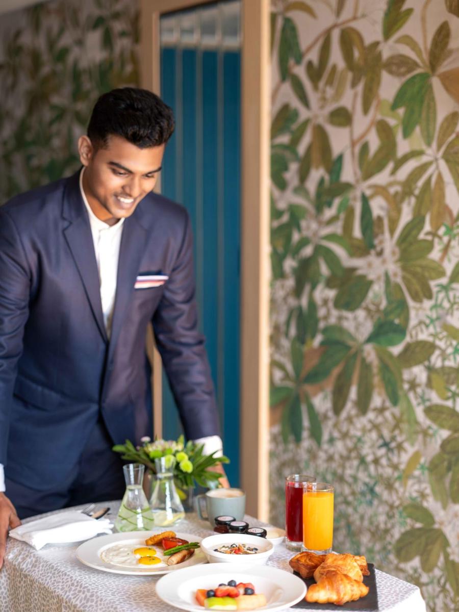 a man in a suit sitting at a table with food at Pullman Chennai Anna Salai - Premium Brand By Accor in Chennai