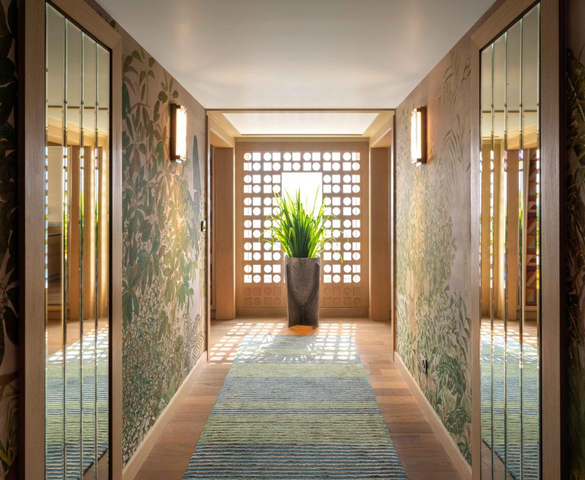 a hallway with a door and a plant in a vase at Pullman Chennai Anna Salai - Premium Brand By Accor in Chennai