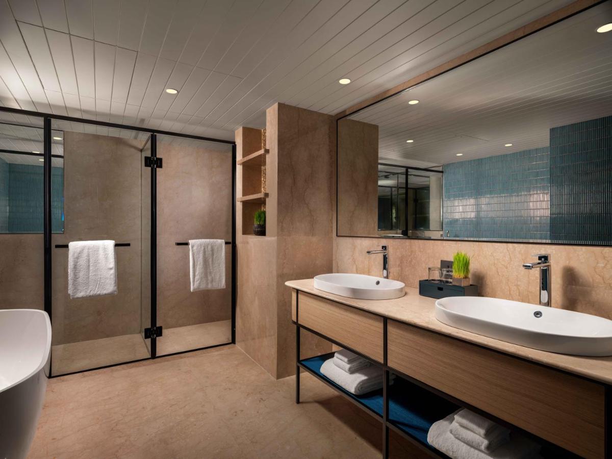 a bathroom with two sinks and a shower at Pullman Chennai Anna Salai - Premium Brand By Accor in Chennai
