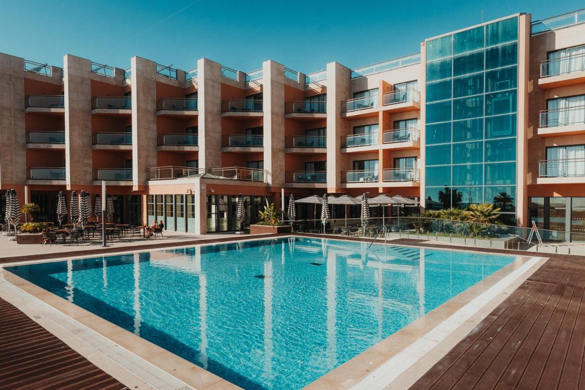 uma imagem de uma piscina em frente a um prédio em Real Marina Hotel & Spa em Olhão