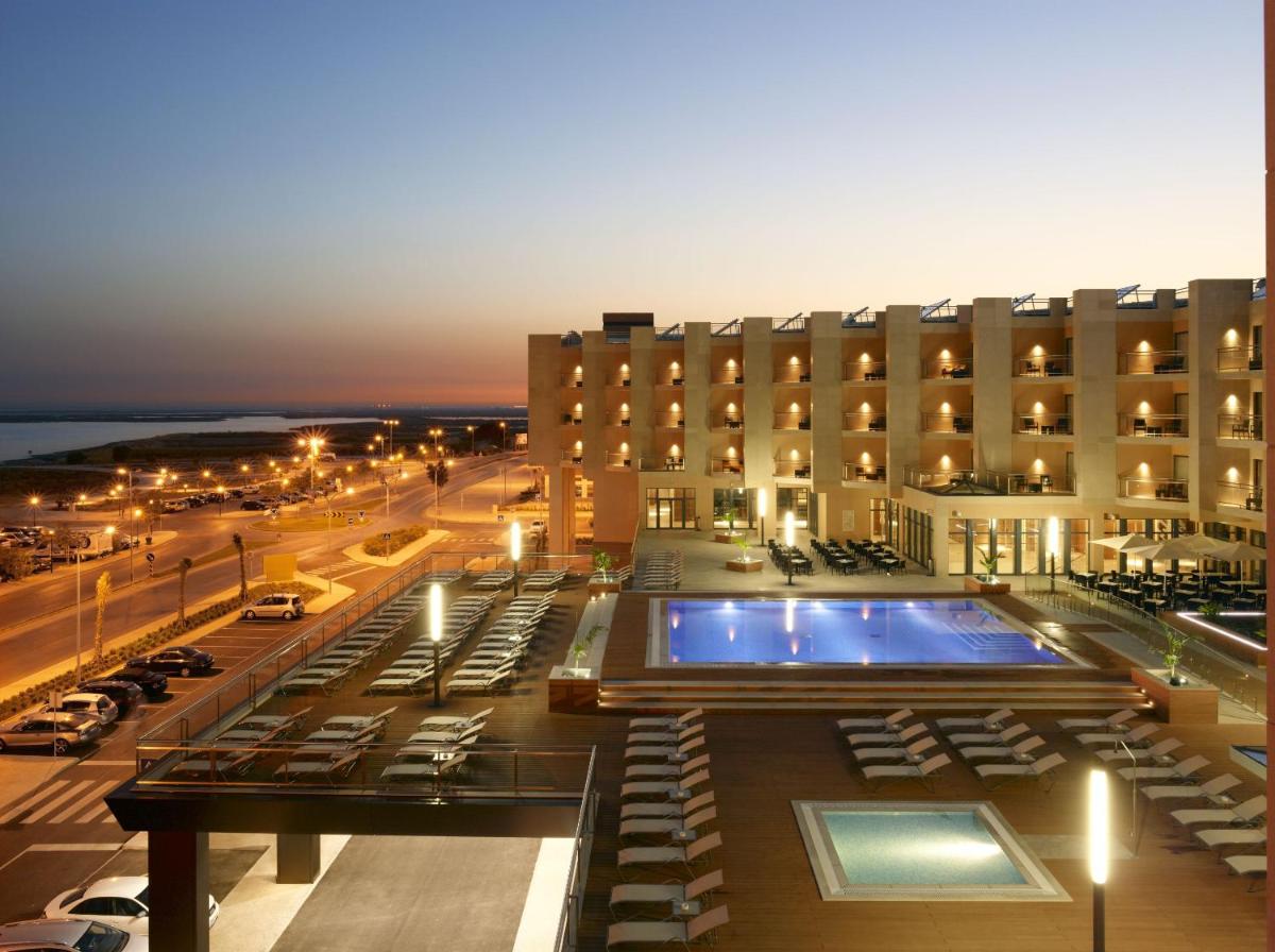 um hotel com piscina em frente a um prédio em Real Marina Hotel & Spa em Olhão