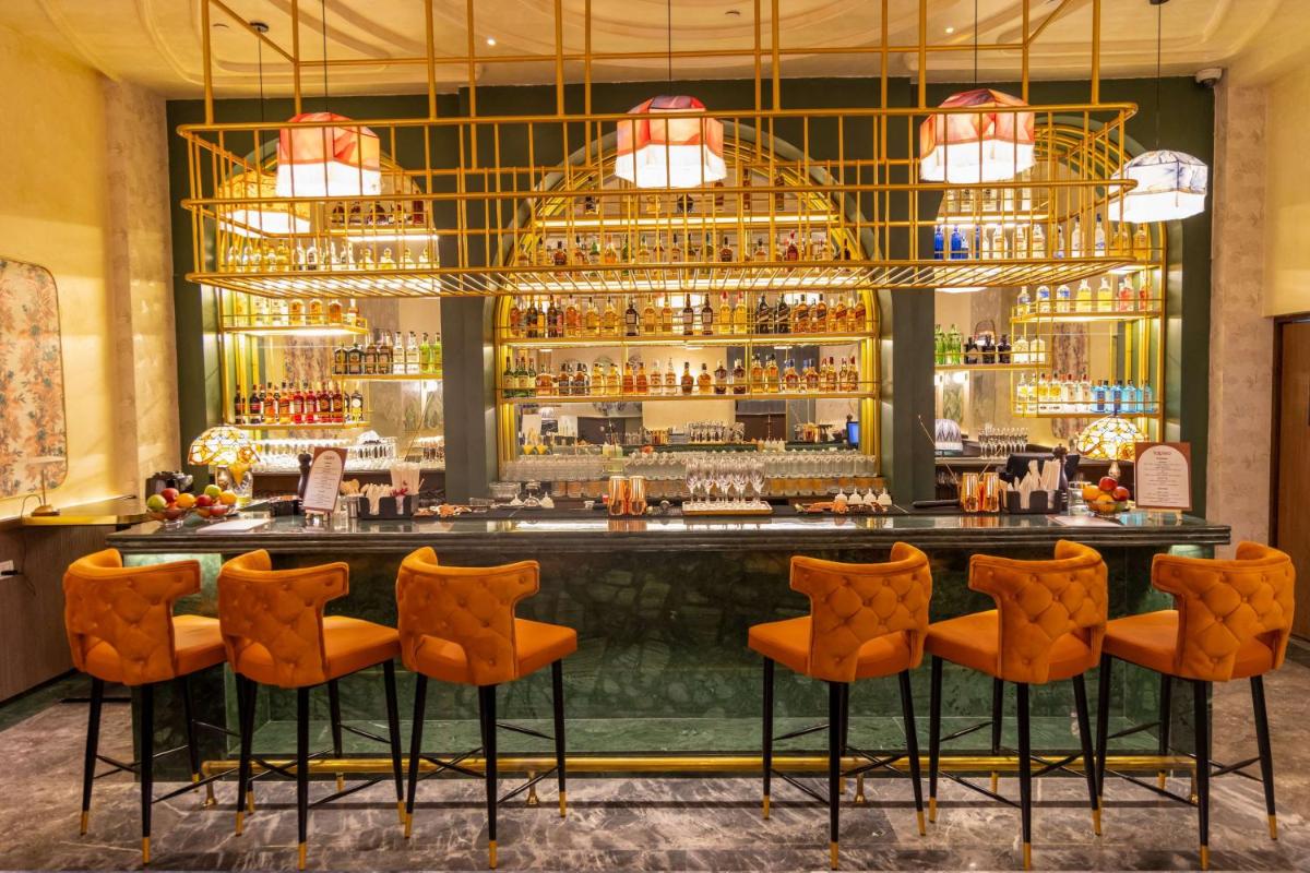 a bar at a hotel with orange chairs at DoubleTree Suites by Hilton Bengaluru Outer Ring Road in Bengaluru