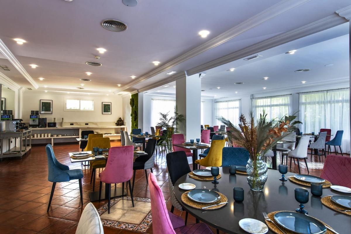 Un comedor con mesas y sillas y un escritorio. en Hotel Tamisa Golf, en Mijas
