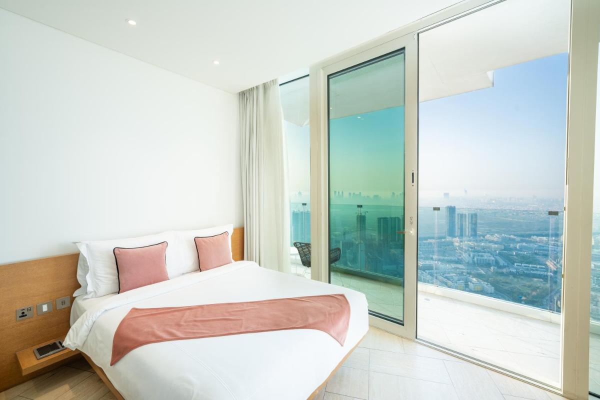 a bedroom with a bed and a large window at FIVE Jumeirah Village in Dubai