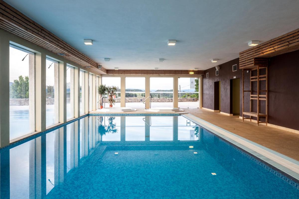 uma piscina numa casa com janelas de vidro em Casas Novas Countryside Hotel Spa & Events em Chaves
