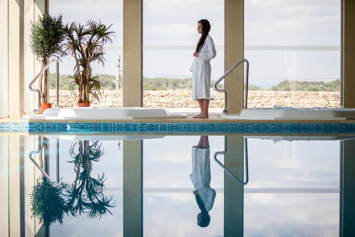 uma mulher parada ao lado de uma piscina em Casas Novas Countryside Hotel Spa & Events em Chaves