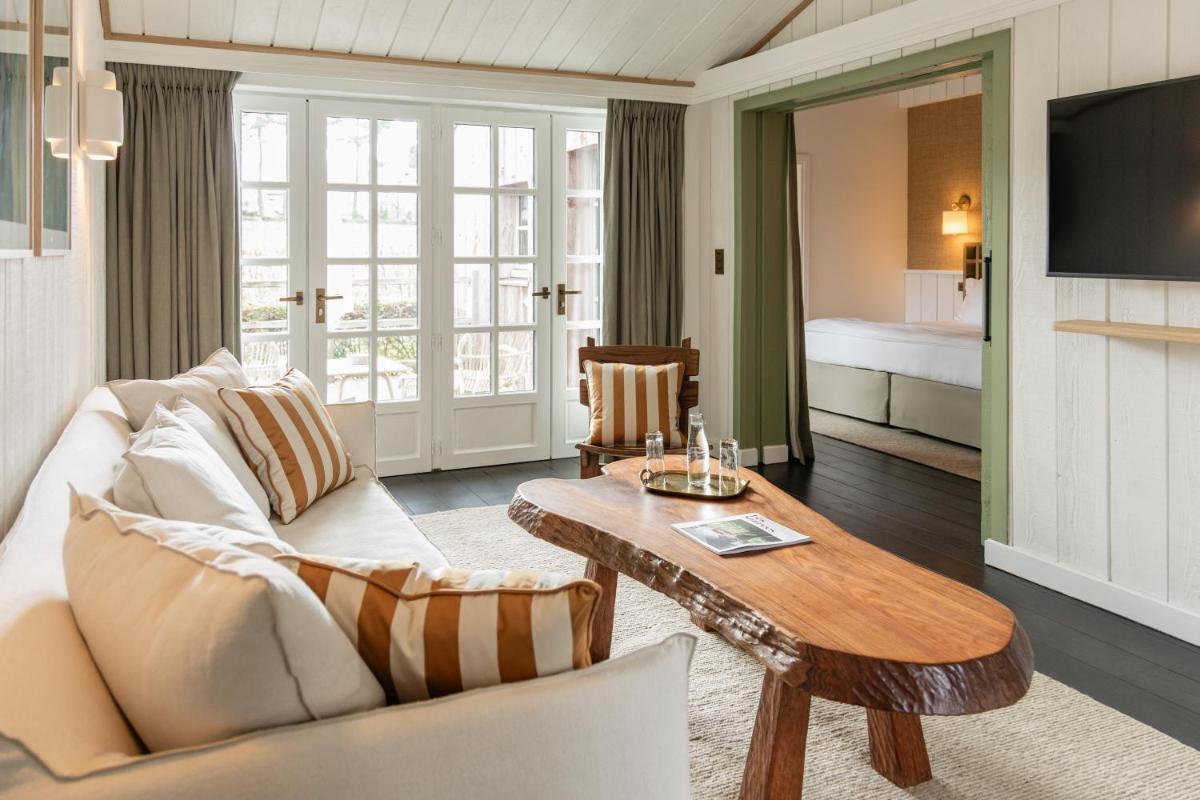 un salon avec un canapé et une table dans l'établissement Les Sources de Caudalie, à Martillac