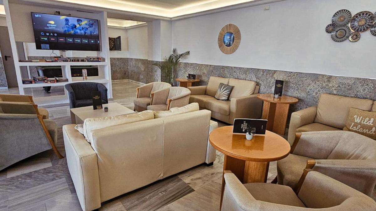 Un vestíbulo con sofás, mesas y un televisor. en Sentido Fido Tucan - Adults Only, en Cala d´Or