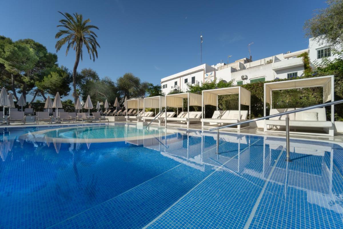 una gran piscina con sillas y sombrillas en Sentido Fido Tucan - Adults Only, en Cala d´Or