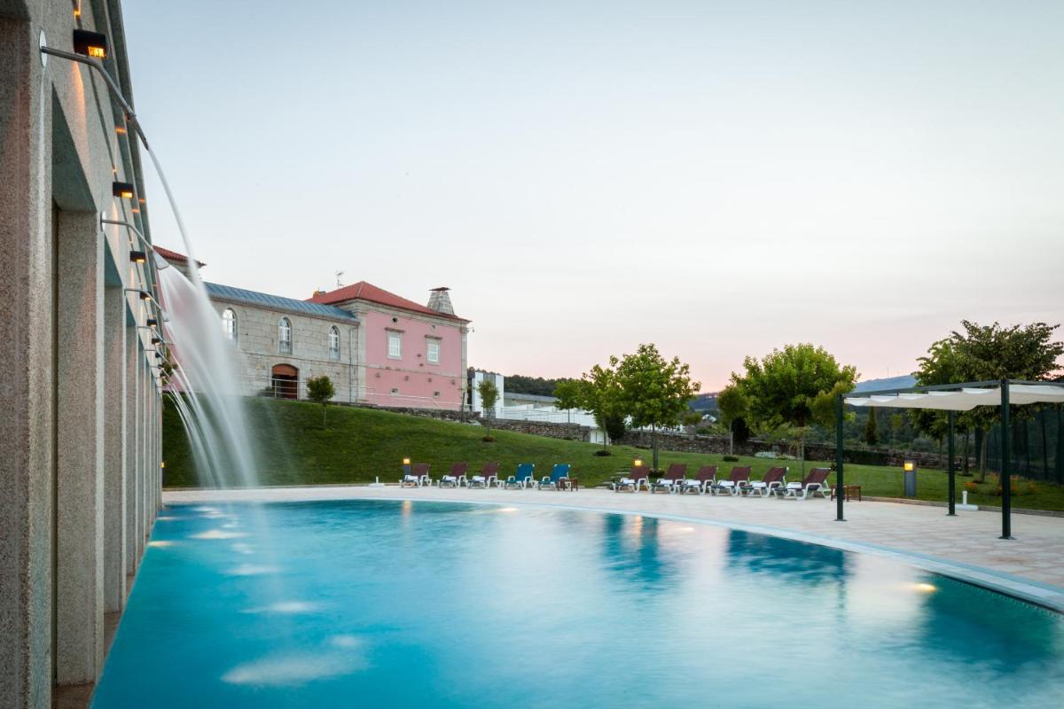 uma piscina com uma fonte em frente a um edifício em Casas Novas Countryside Hotel Spa & Events em Chaves