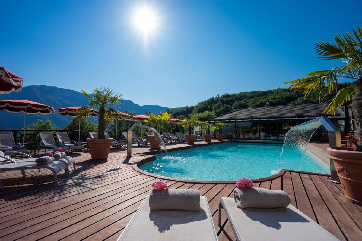 - une piscine sur une terrasse avec des chaises et des parasols dans l'établissement Les Trésoms Lake and Spa Resort, à Annecy