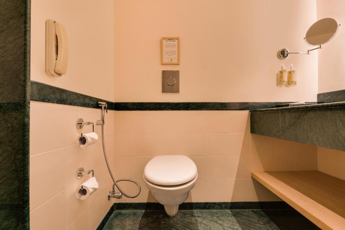 a bathroom with a toilet and a sink at Lemon Tree Premier Hitec City Hyderabad in Hyderabad