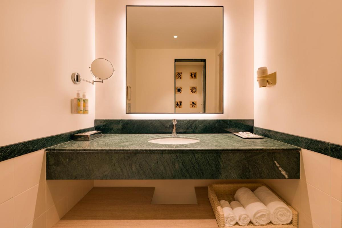 a bathroom with a sink and a mirror at Lemon Tree Premier Hitec City Hyderabad in Hyderabad a bathroom with a sink and a mirror at Lemon Tree Premier Hitec City Hyderabad in Hyderabad