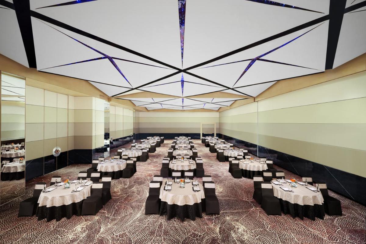 a large banquet hall with white tables and chairs at Novotel New Delhi City Centre in New Delhi a large banquet hall with white tables and chairs at Novotel New Delhi City Centre in New Delhi
