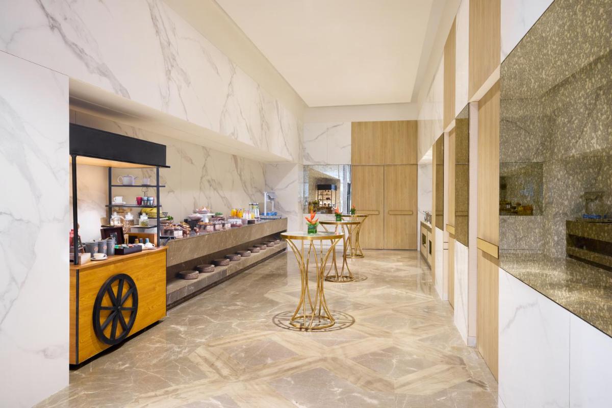 a large kitchen with a table in the middle of a room at Novotel New Delhi City Centre in New Delhi a large kitchen with a table in the middle of a room at Novotel New Delhi City Centre in New Delhi